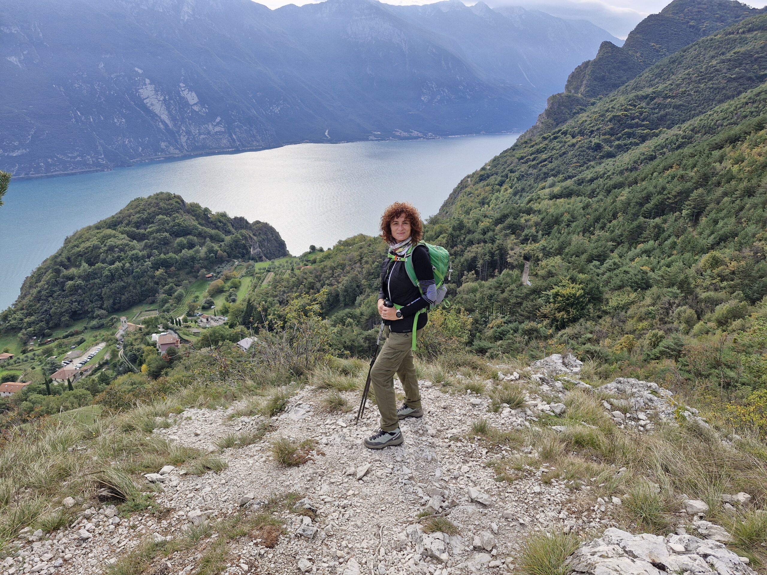 Donna vestita da trekking su paesaggio montano con vista lago. I migliori consigli su trekking