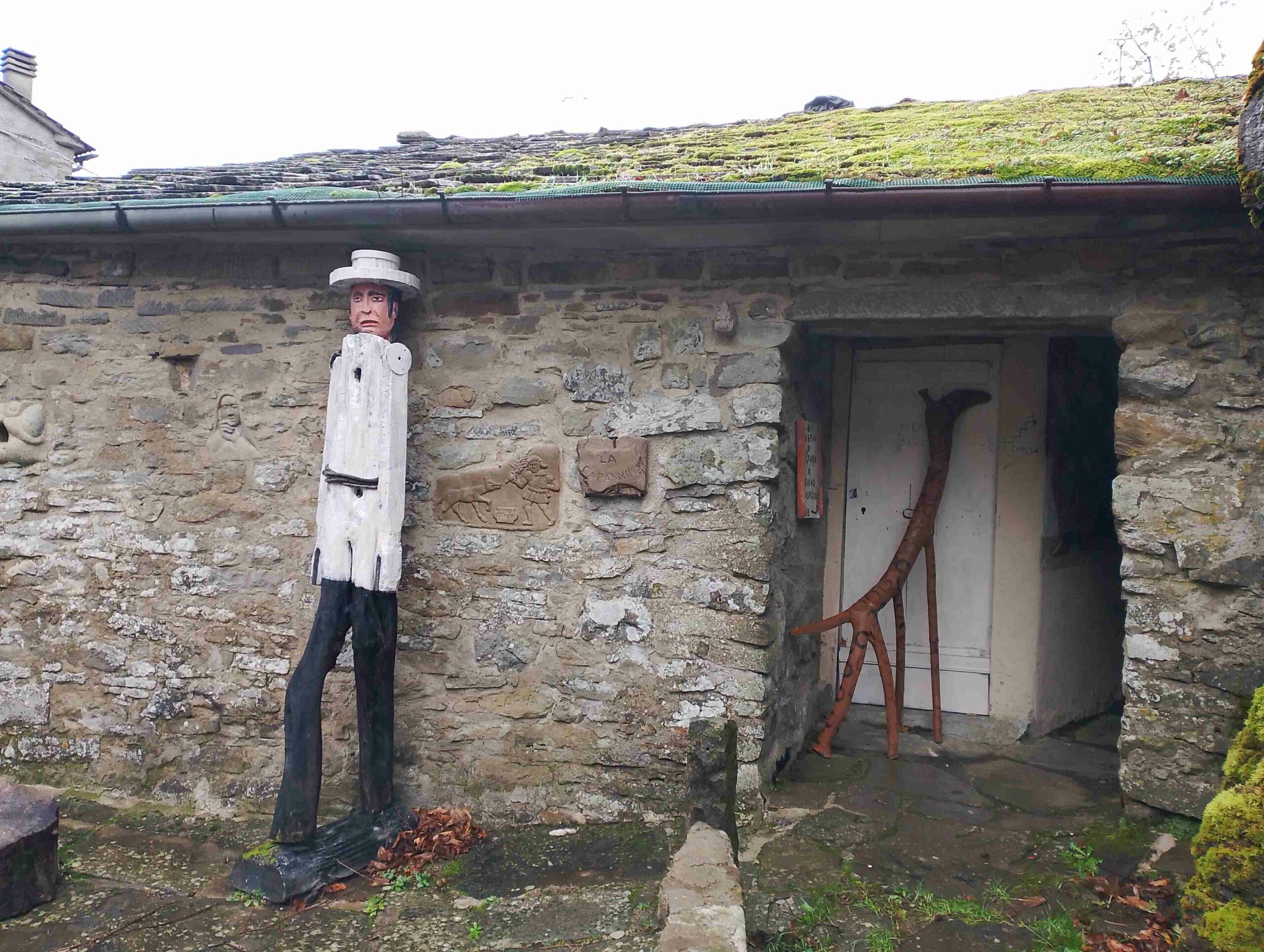 Immagine di una casa in pietra con due opere d'arte casalinghe ed autentiche. I migliori percorsi di trekking nel nostro appennino toscoemiliano