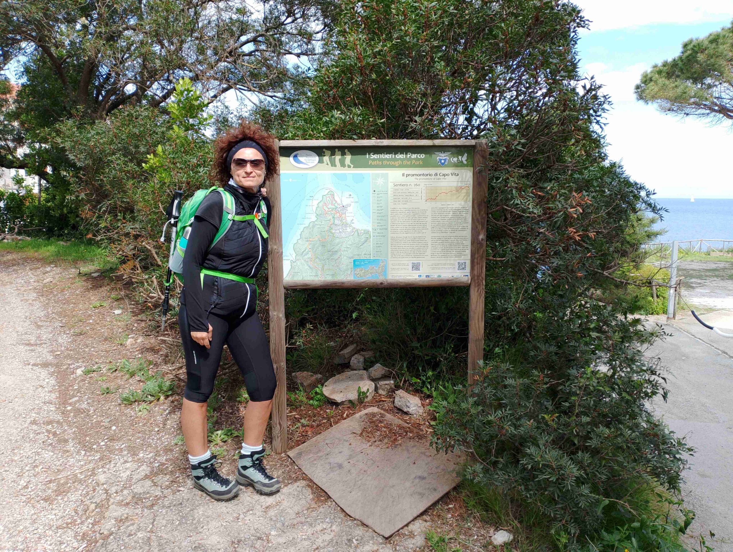 Donna vestita da trekking appoggiata a mappa sentieristica per i migliori suggerimenti di percorsi di trekking