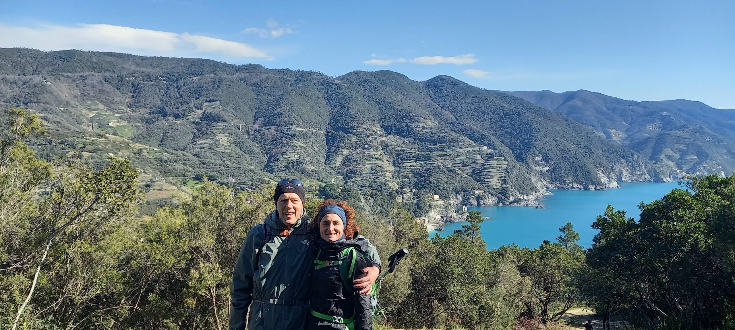 Una coppia di trekking in posa in un punto panoramico ligure per i migliori percorsi di trekking